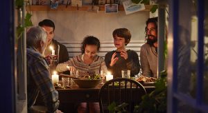 Family having cozy dinner en garden house